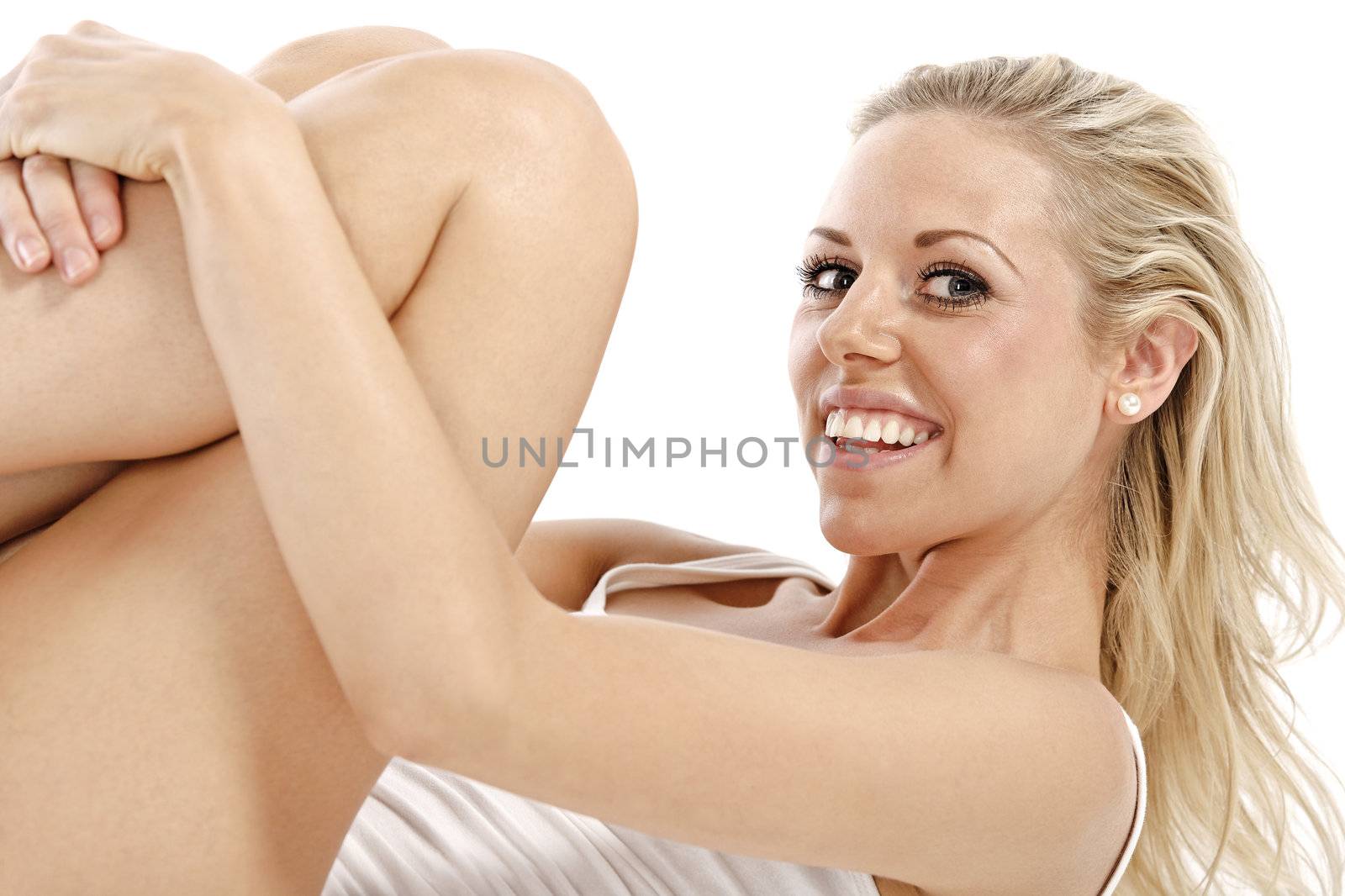 Attractive young woman in a white vest top sitting on the floor on white background