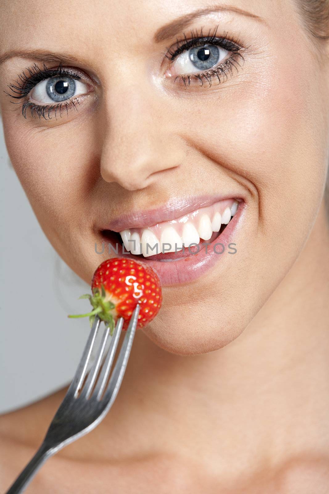 Beautiful young woman eating fresh summer berries