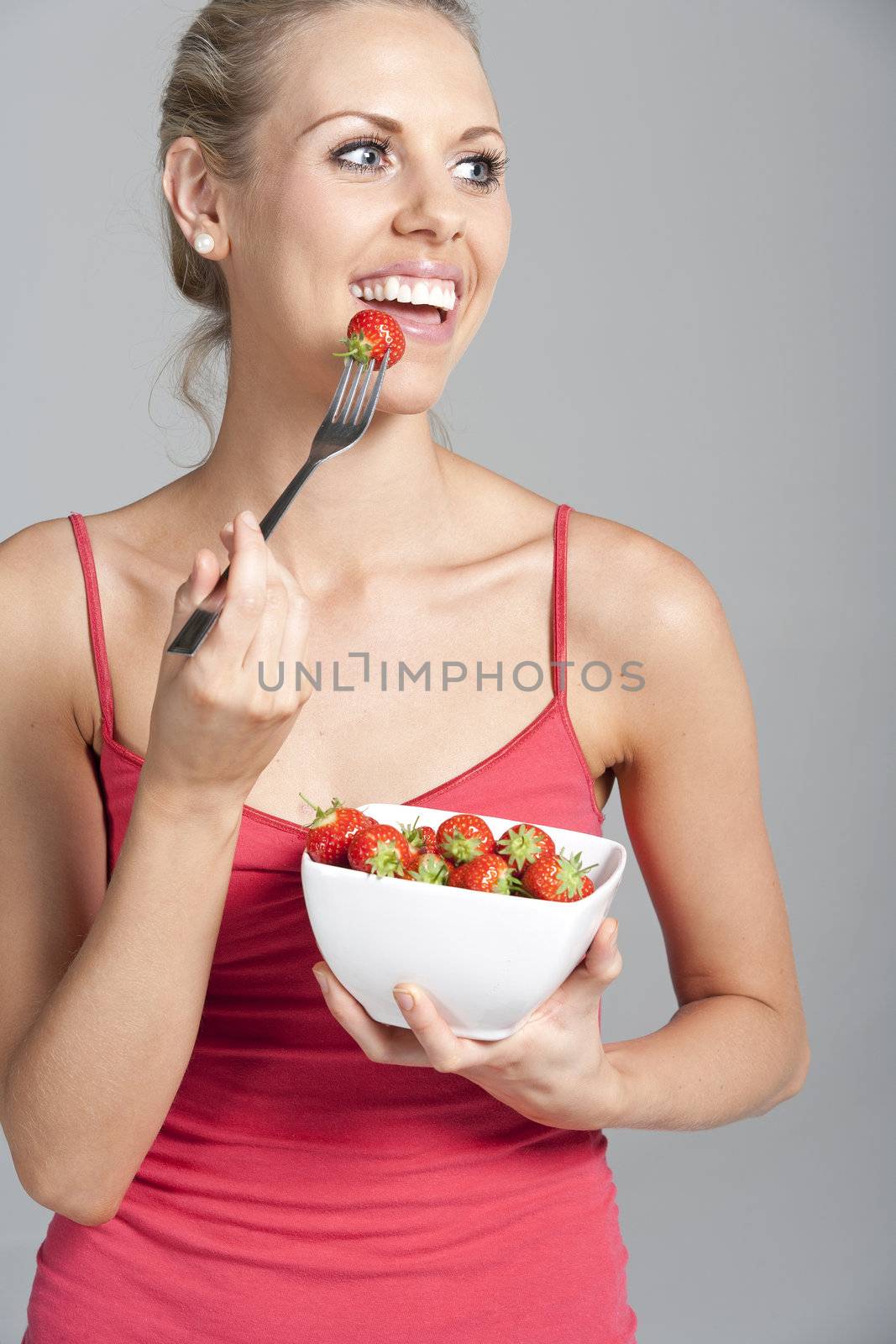 Beautiful young woman eating fresh summer berries