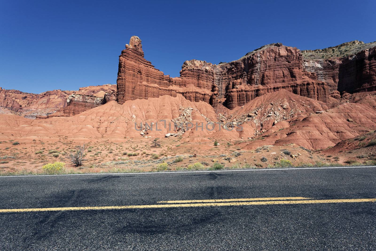 A highway rolling through red rock canyons