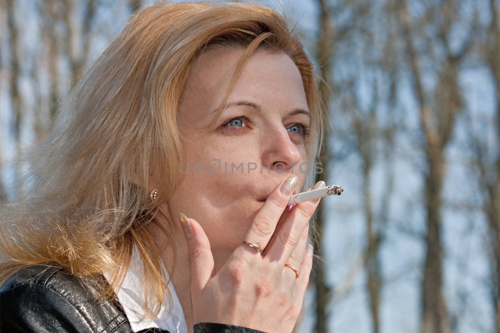 pretty girl smoking in the park in sunny day