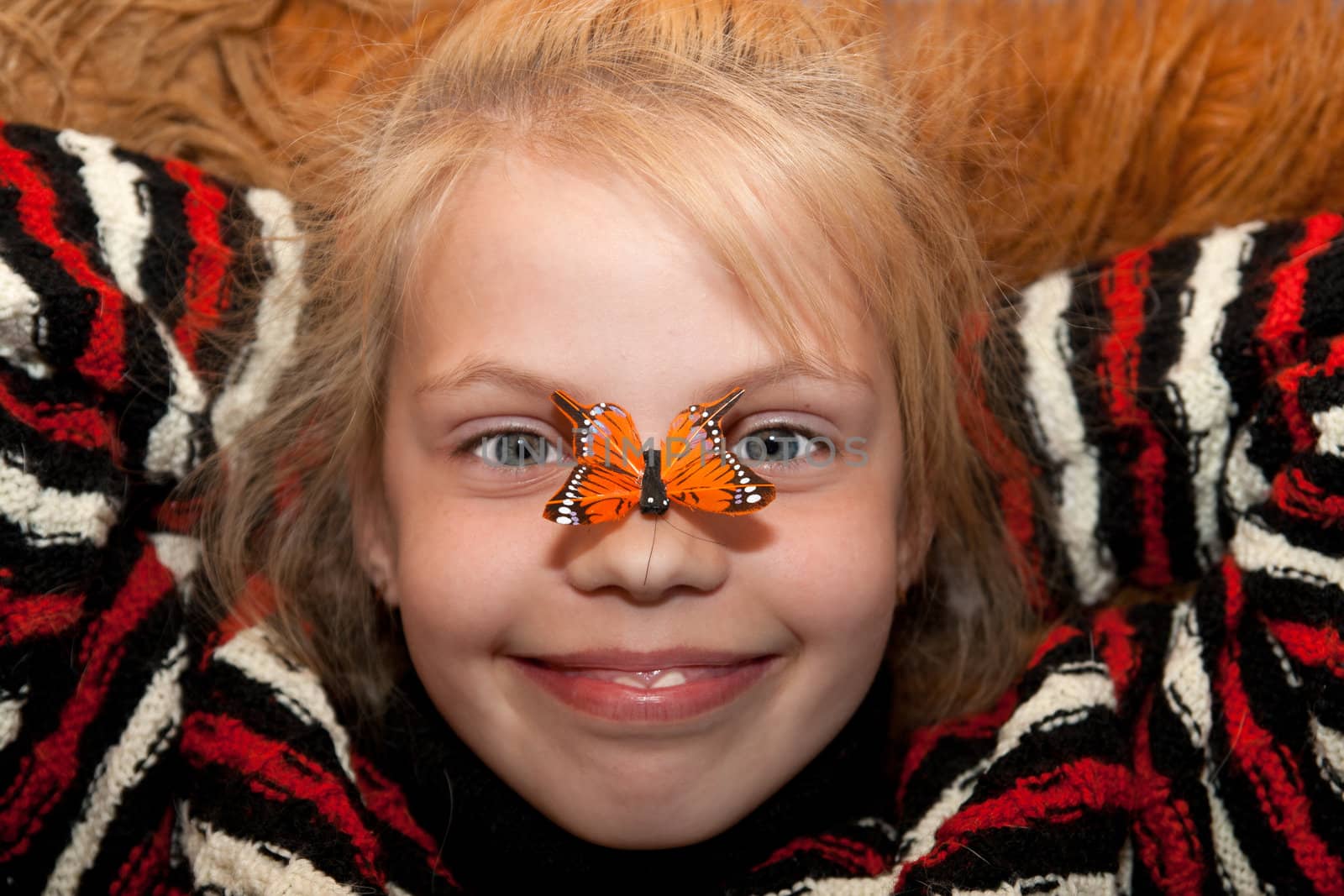 A little girl with butterfly on nose