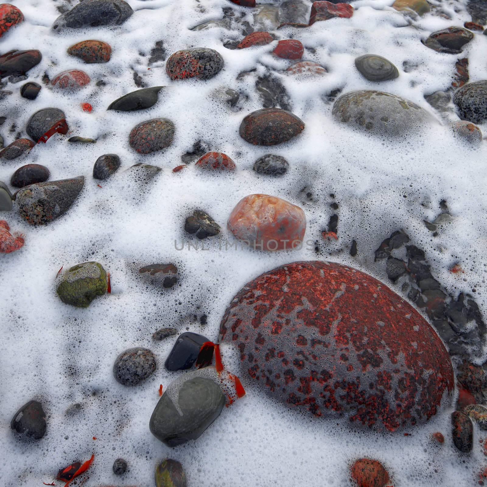 Close up of water flowing between rolling stones