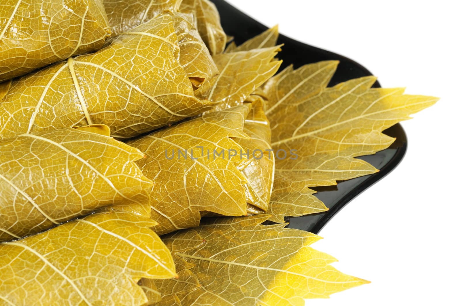 Dolma on a black plate. Isolated on white background.