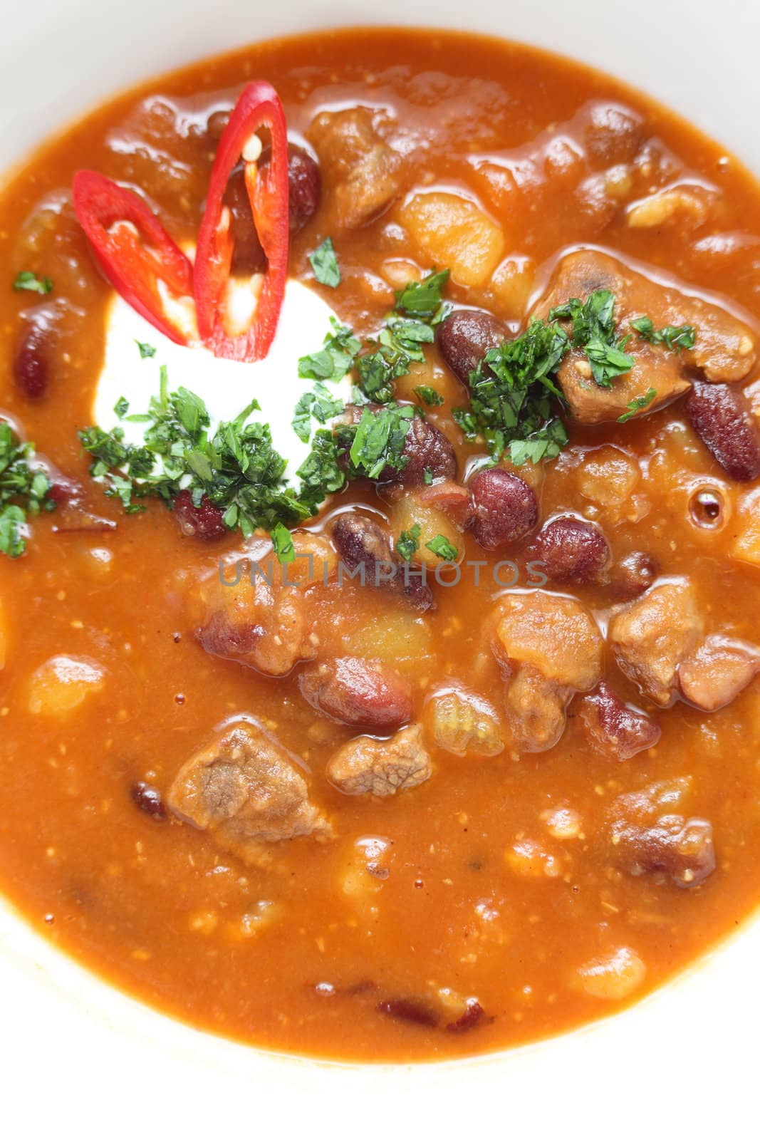 Hot soup in the white dish on wooden table