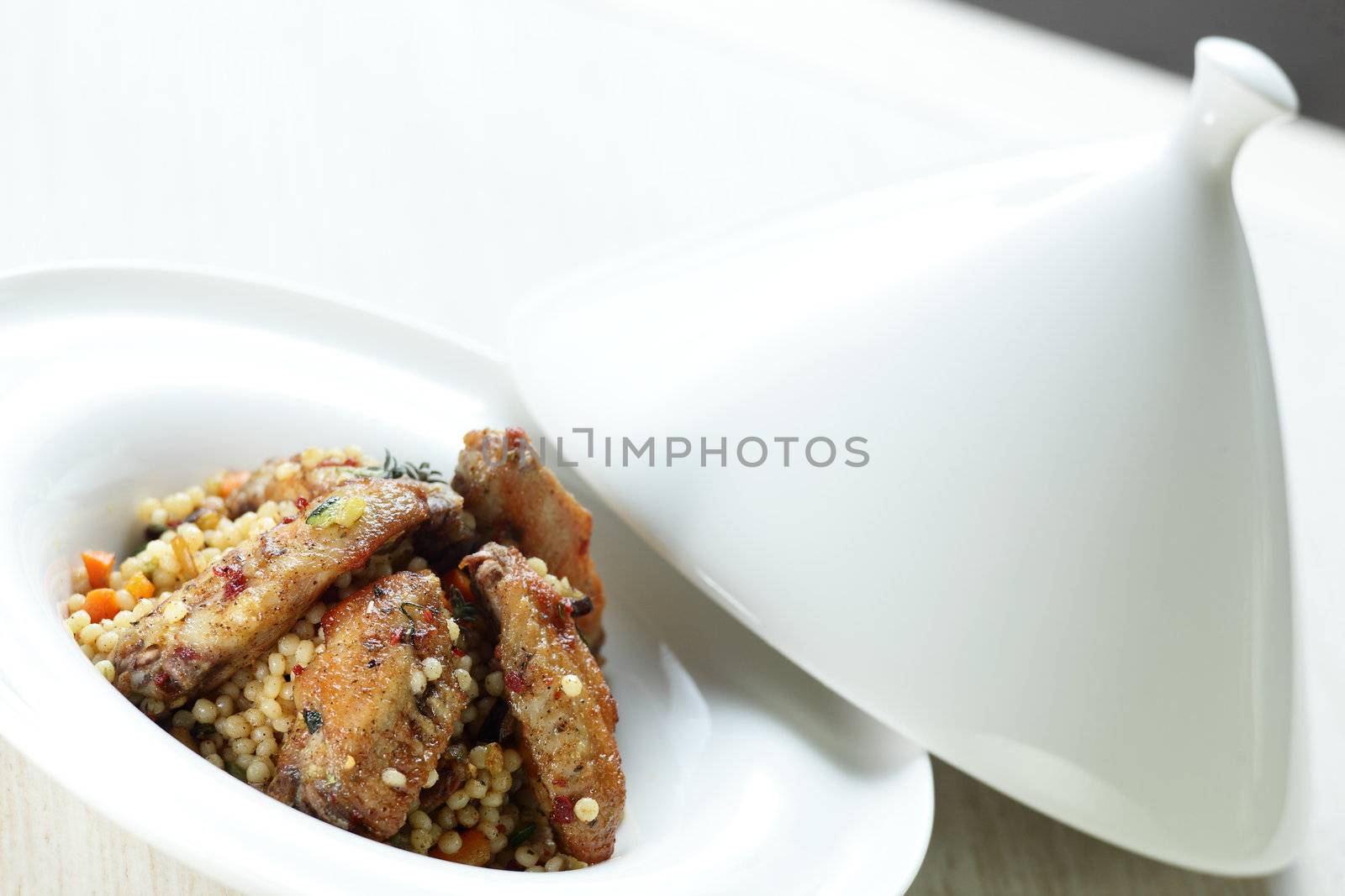 Peaces of meat with millet in the white dish