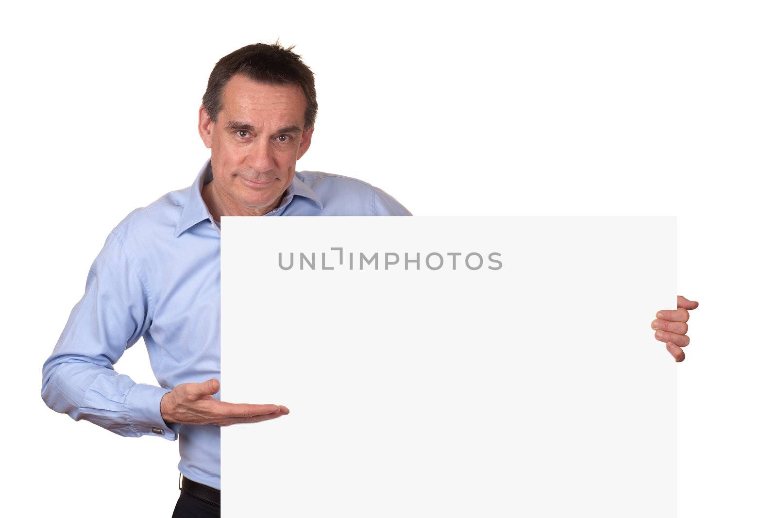 Attractive Middle Age Man in Blue Shirt Pointing to Blank White Sign with Copy Space on Right Isolated