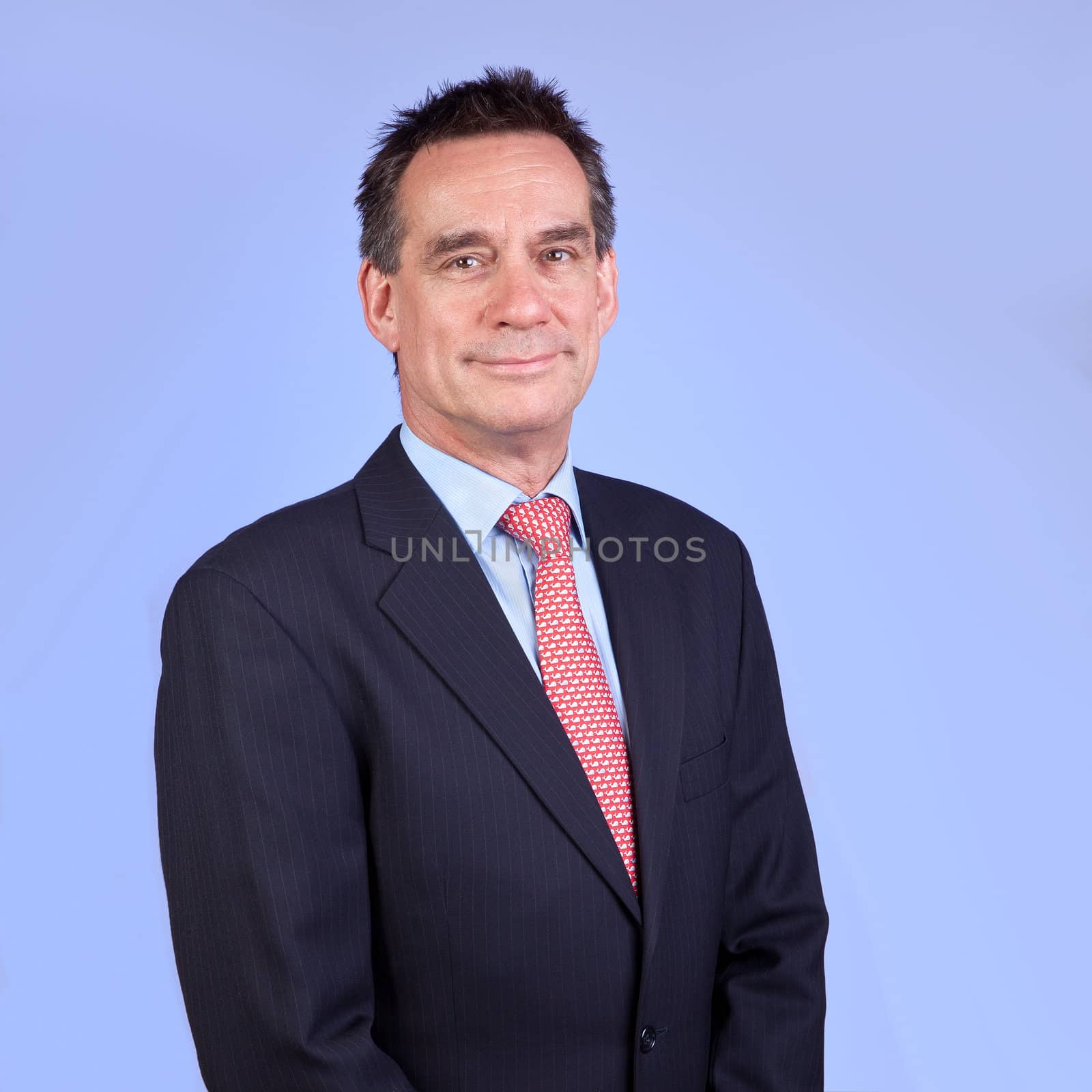 Attractive Smiling Business Man in Suit on Blue Background
