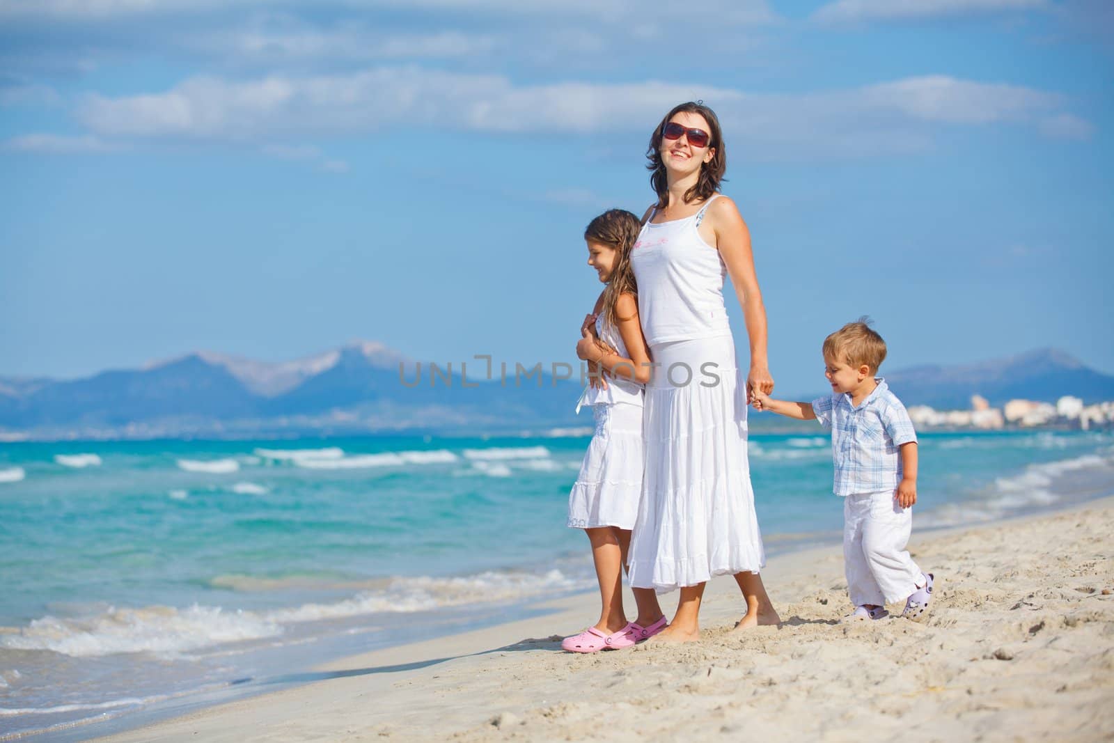 Young mother with her two kids on tropical beach vacation