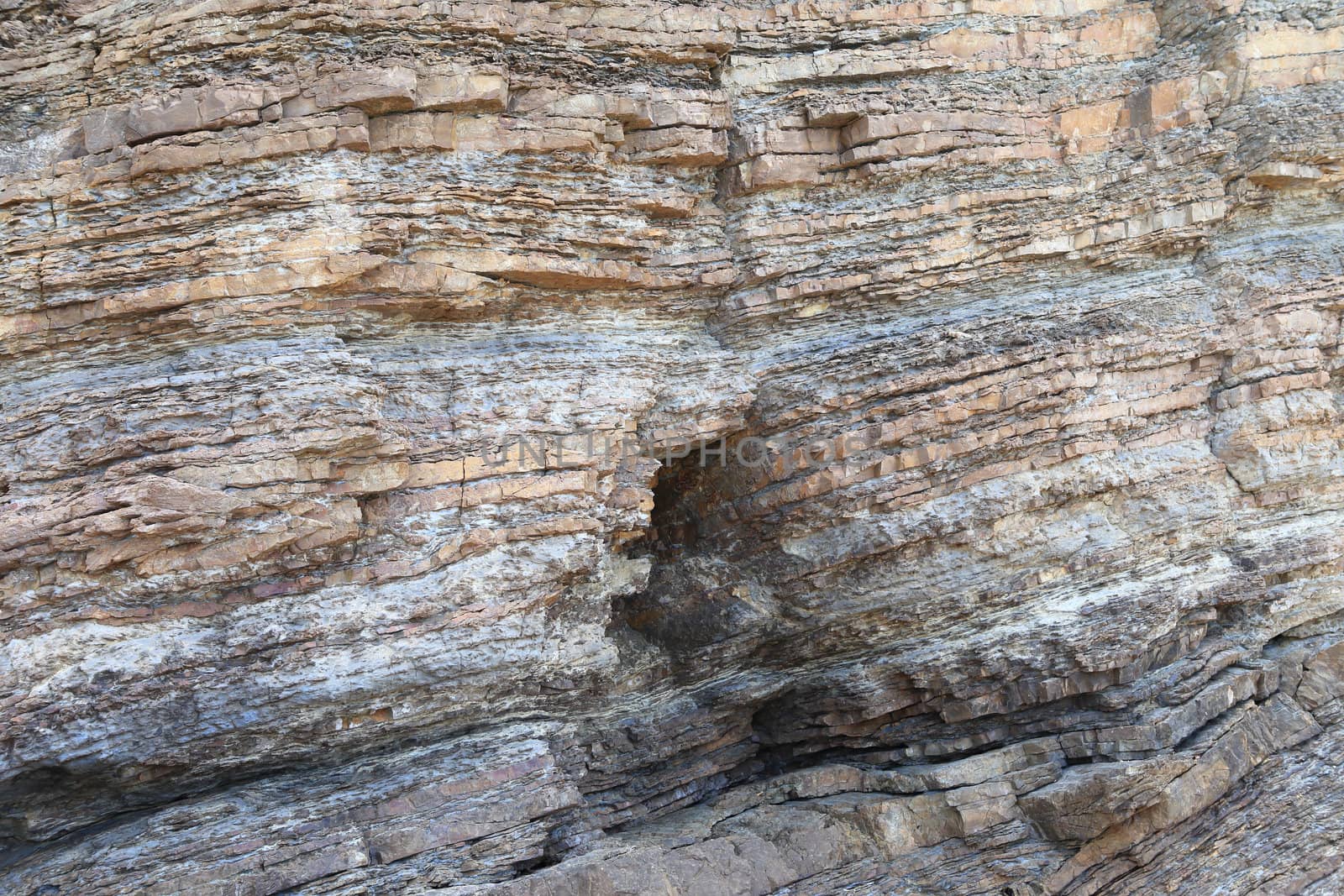 Layered rock on high steep sea bank