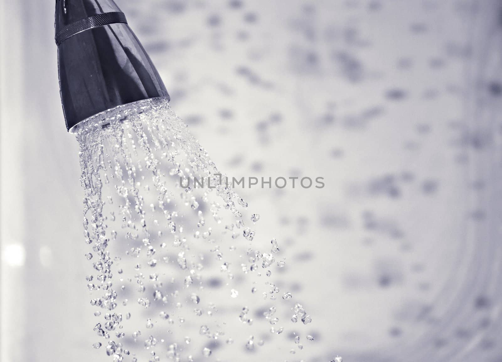 Water comming out of shower head with shadows of the droplets in the background