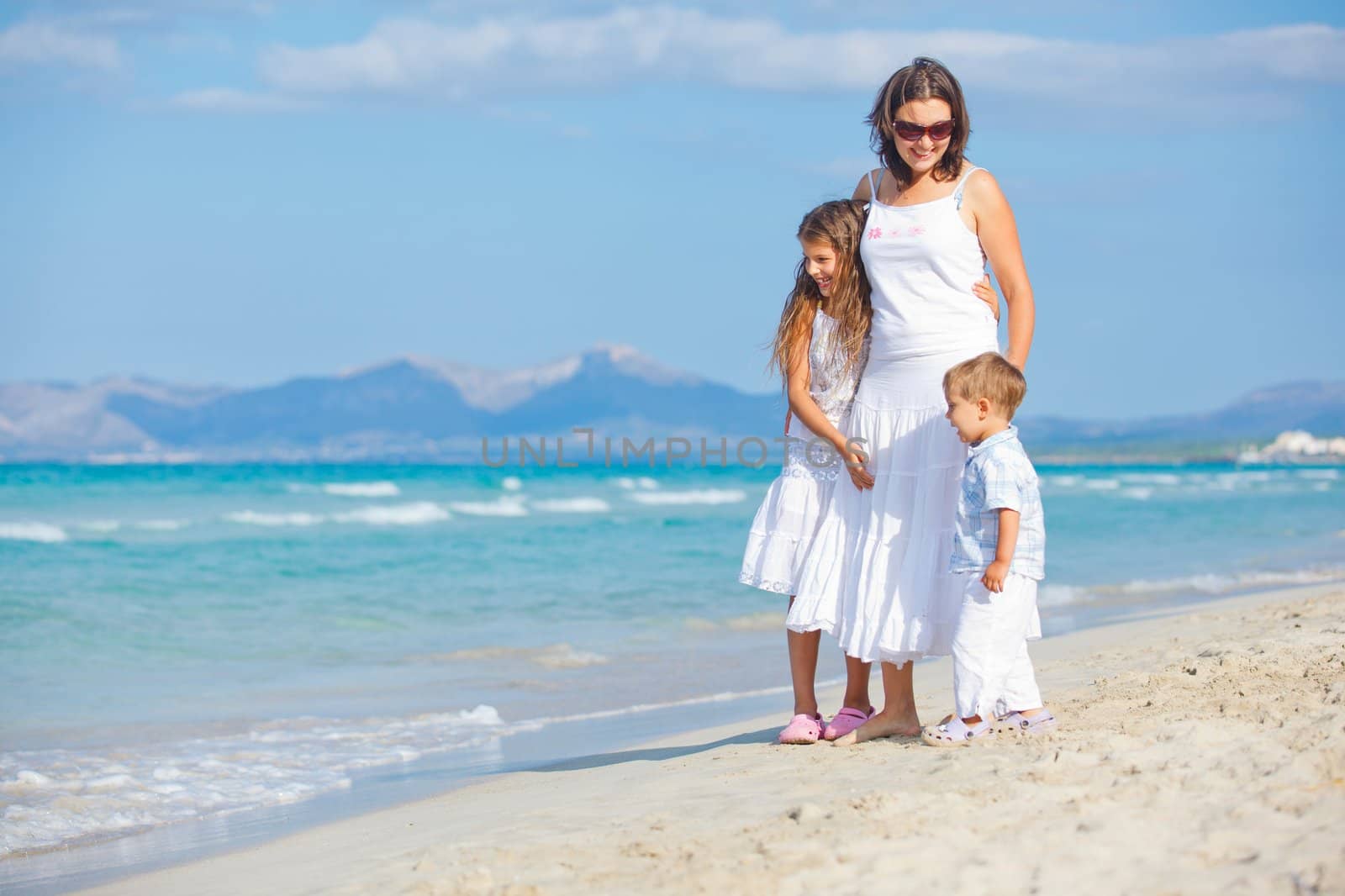 Young mother with her two kids on tropical beach vacation