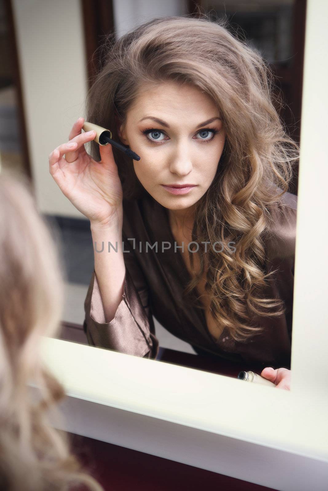 The young beautiful girl does makeup