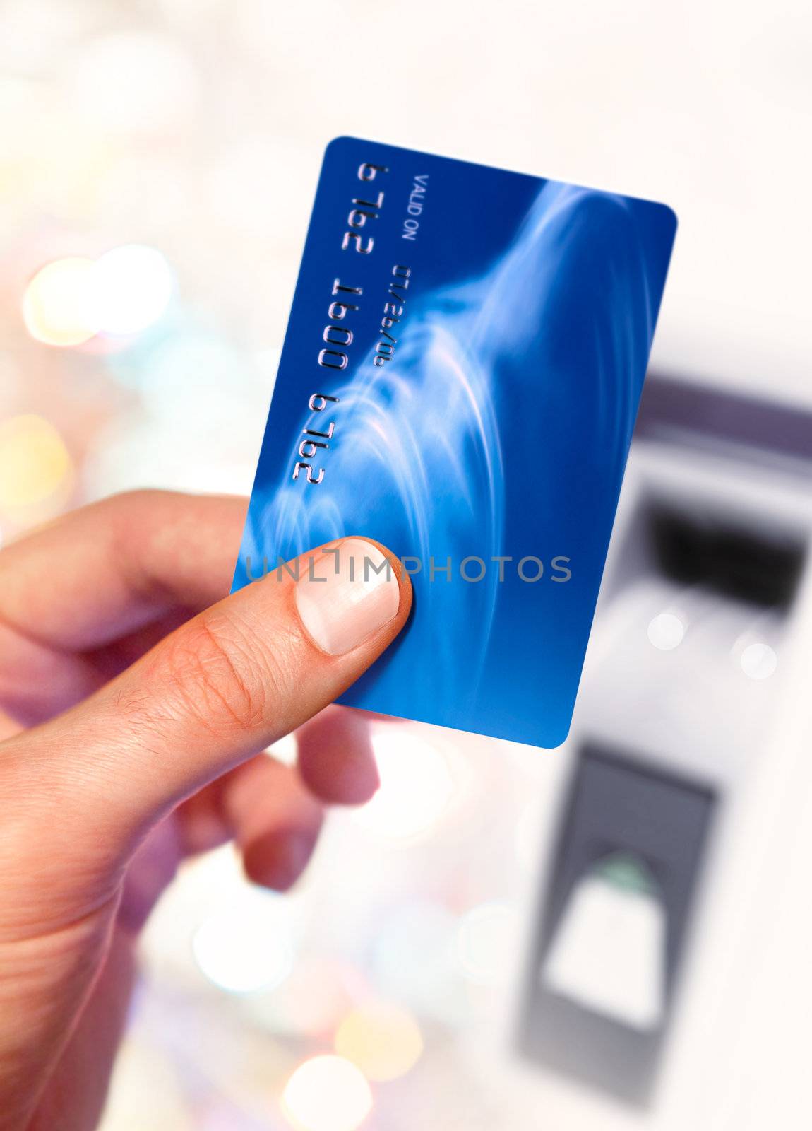 Close-up of man hand holding plastik credit card near ATM