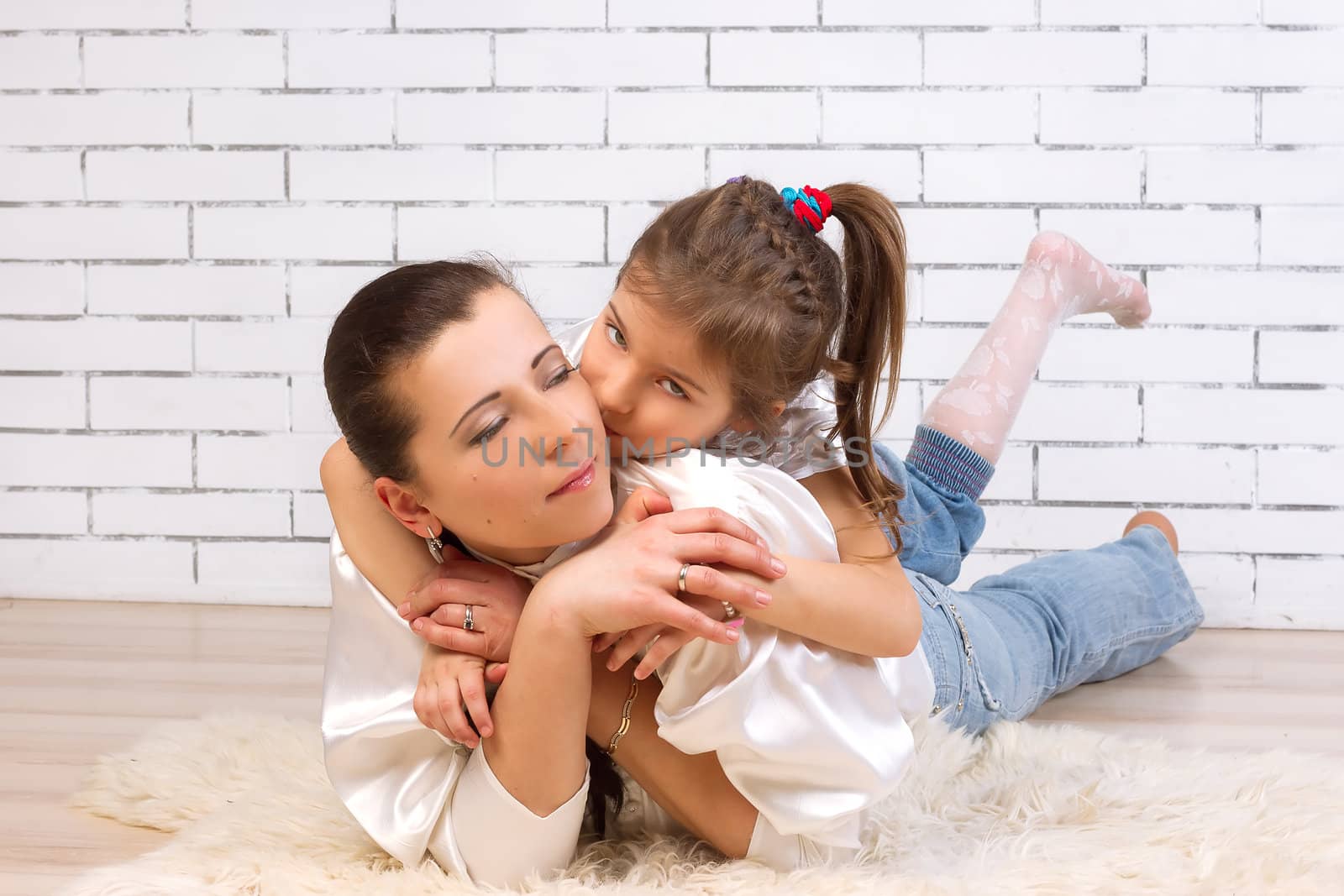 Portrait of a 5 year old daughter riding on my mom hugs and kisses her on the wall