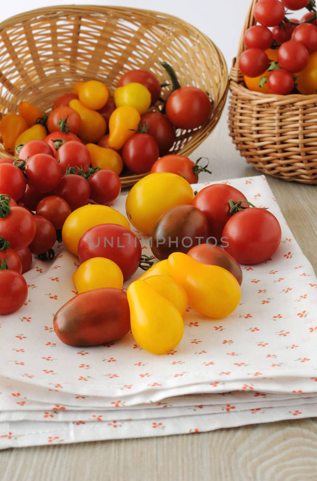 Scattered different varieties of tomatoes from the basket on a napkin