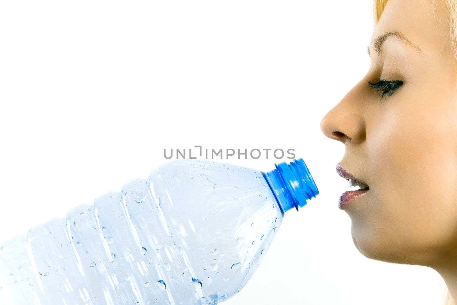 Young beautiful woman drinking mineral water isolated on white.