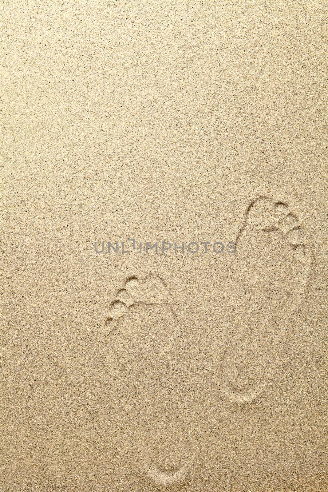 Sandy summer beach background with footprints. Copy space
