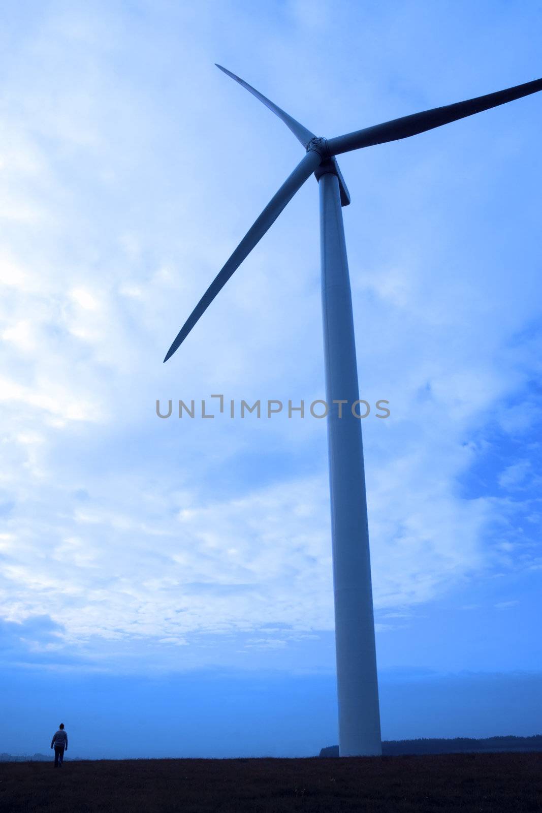 woman and windmill in silhouette on irish tipperary countryside by morrbyte