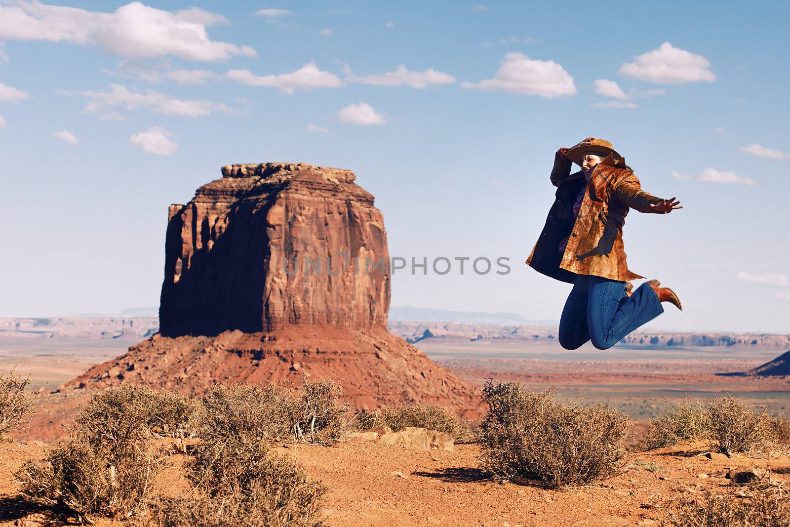 cowgirl jumping at Monument Valley, Utah, USA