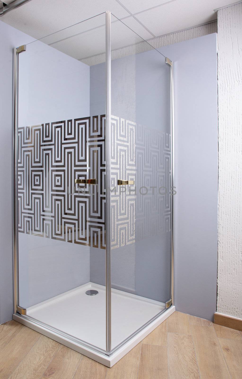 Brand new shower on bright background and wooden floor