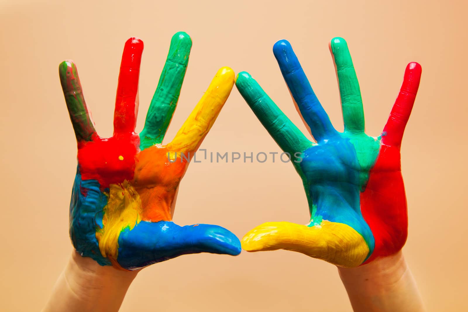 Painted hands, colorful fun. Creative, funny and artistic means happy! Orange background wall