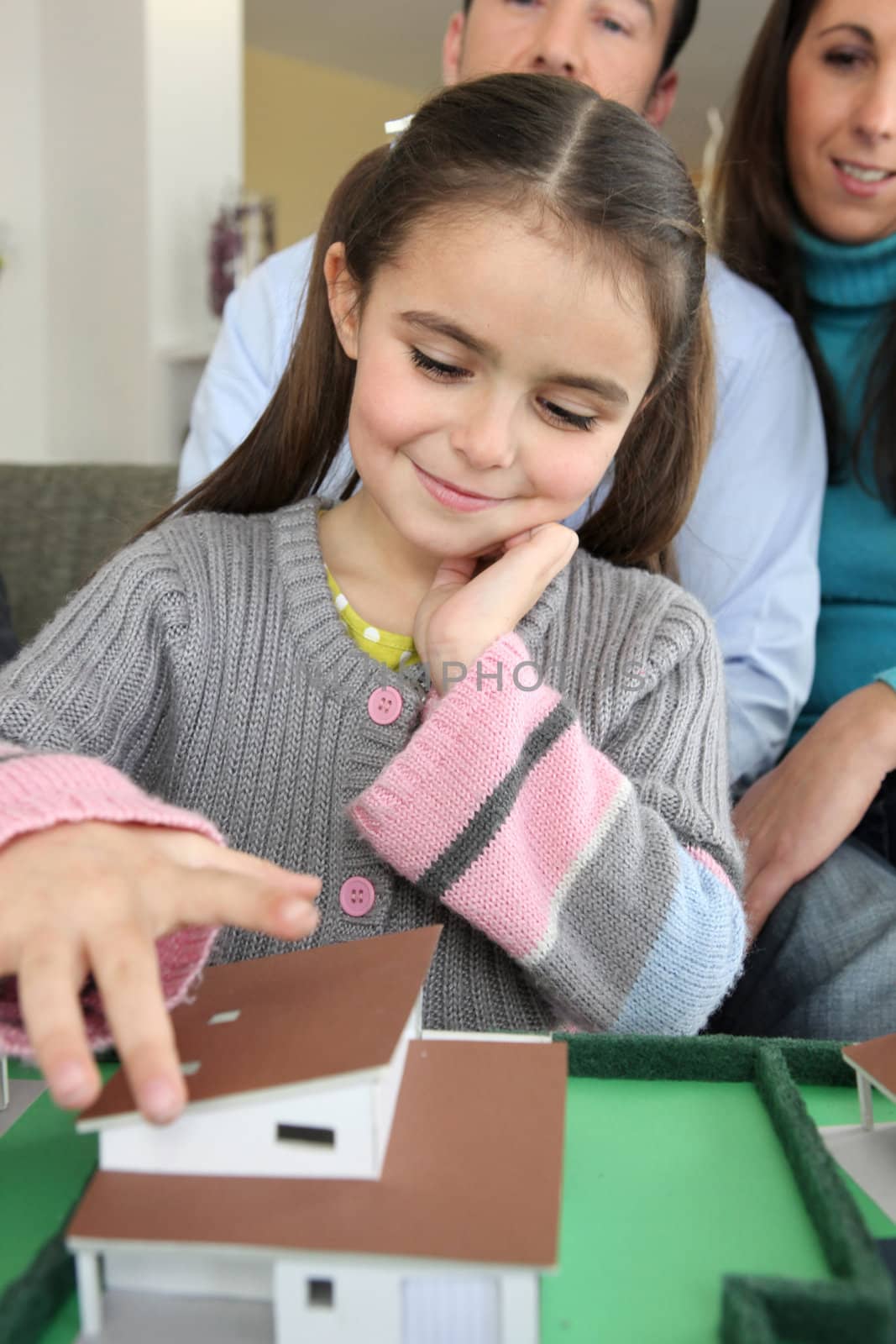 Little girl playing with model house