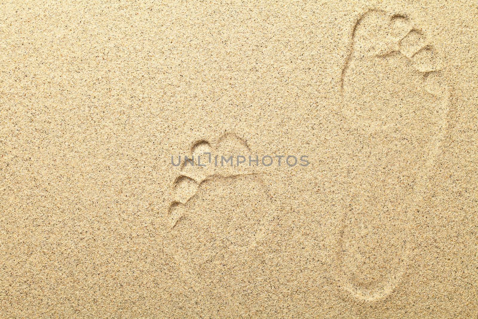 Sandy beach background with footprints. Copy space, macro shot 