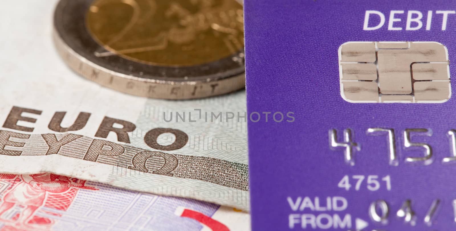 Macro of debit card and on top of euro note to illustrate currency crisis in Europe