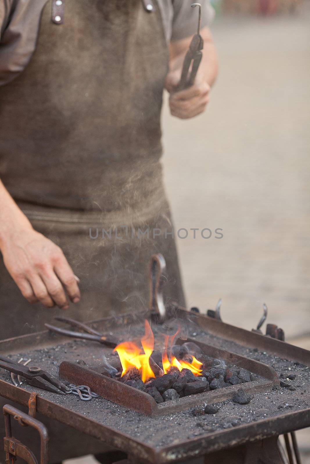 embers, fire, smoke, tools and the hands of a blacksmith