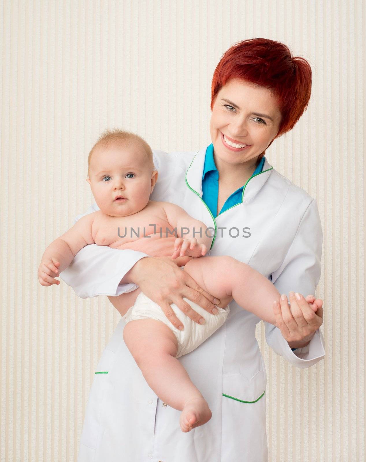Smiling doctor with beautiful baby in hands