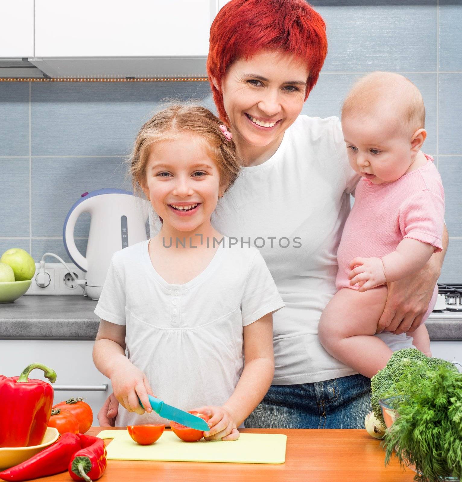 Mother with two daughters in the kitchen with vegetables