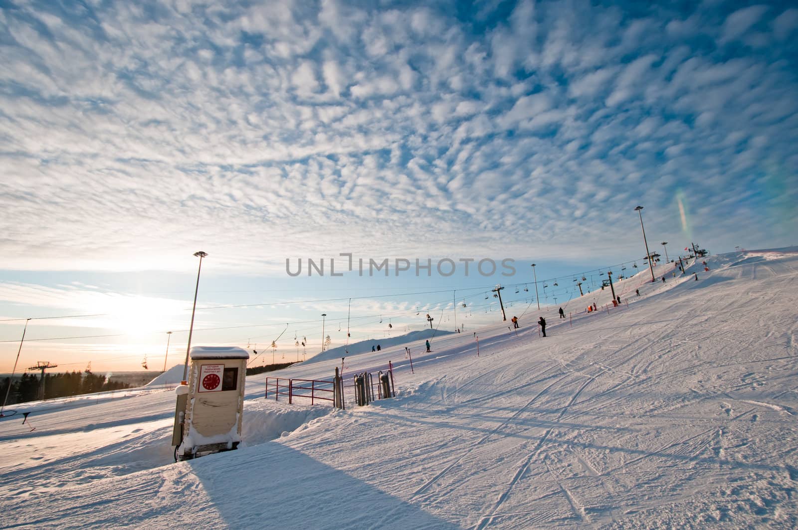 Ski slope at sunrise with few tracks and trails