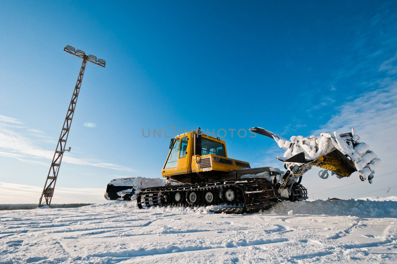 Yellow snowcat standing on top of the mountain