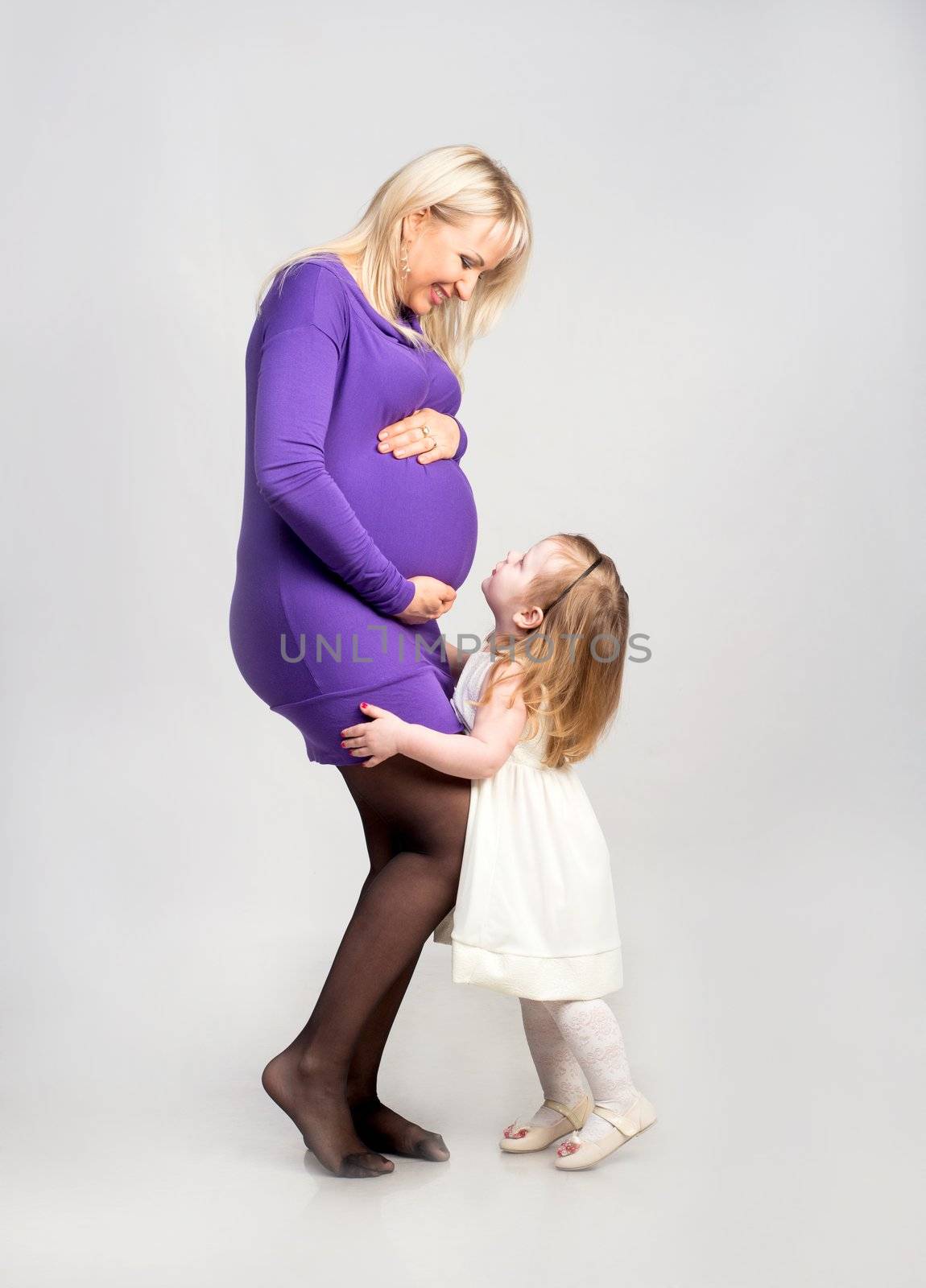 Beautiful pregnant woman with her nice daughter