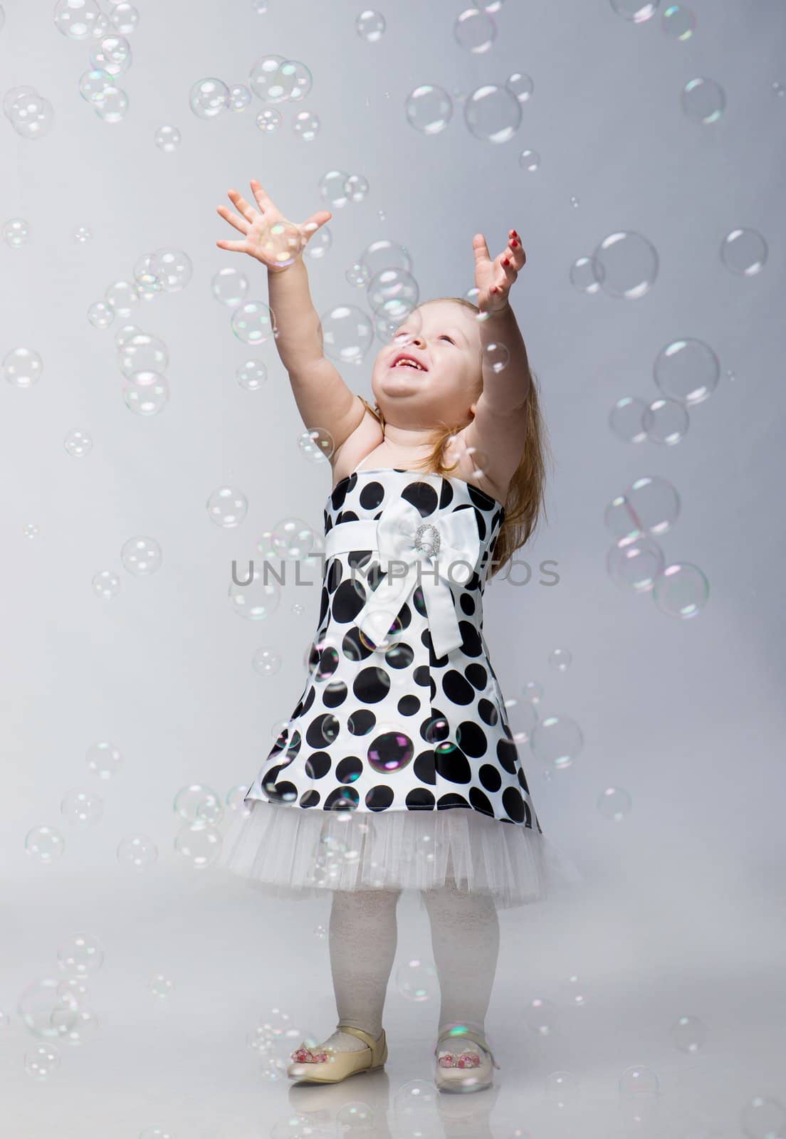 little girl with soap bubbles in studio