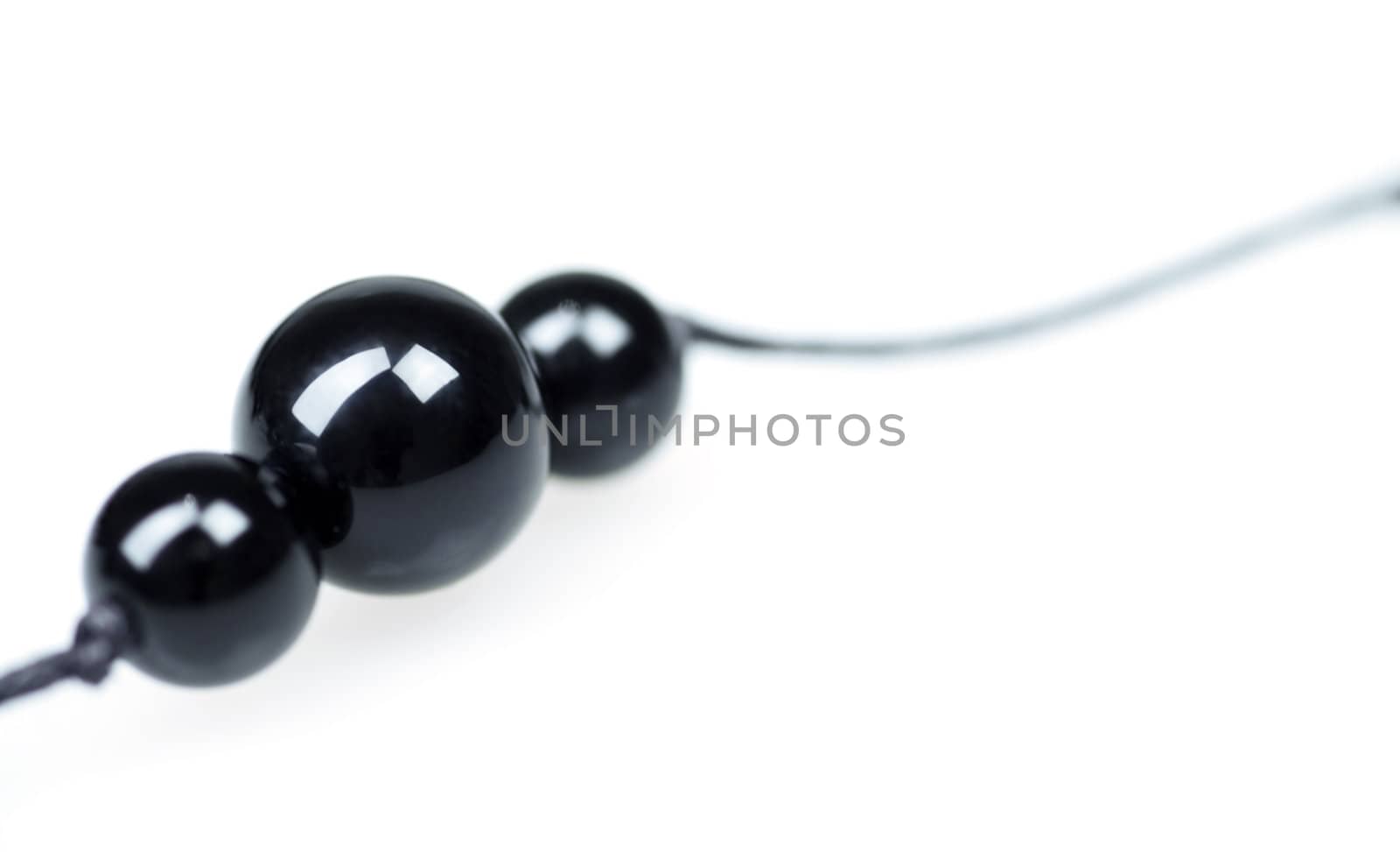 Three black balls from a beads on a white background