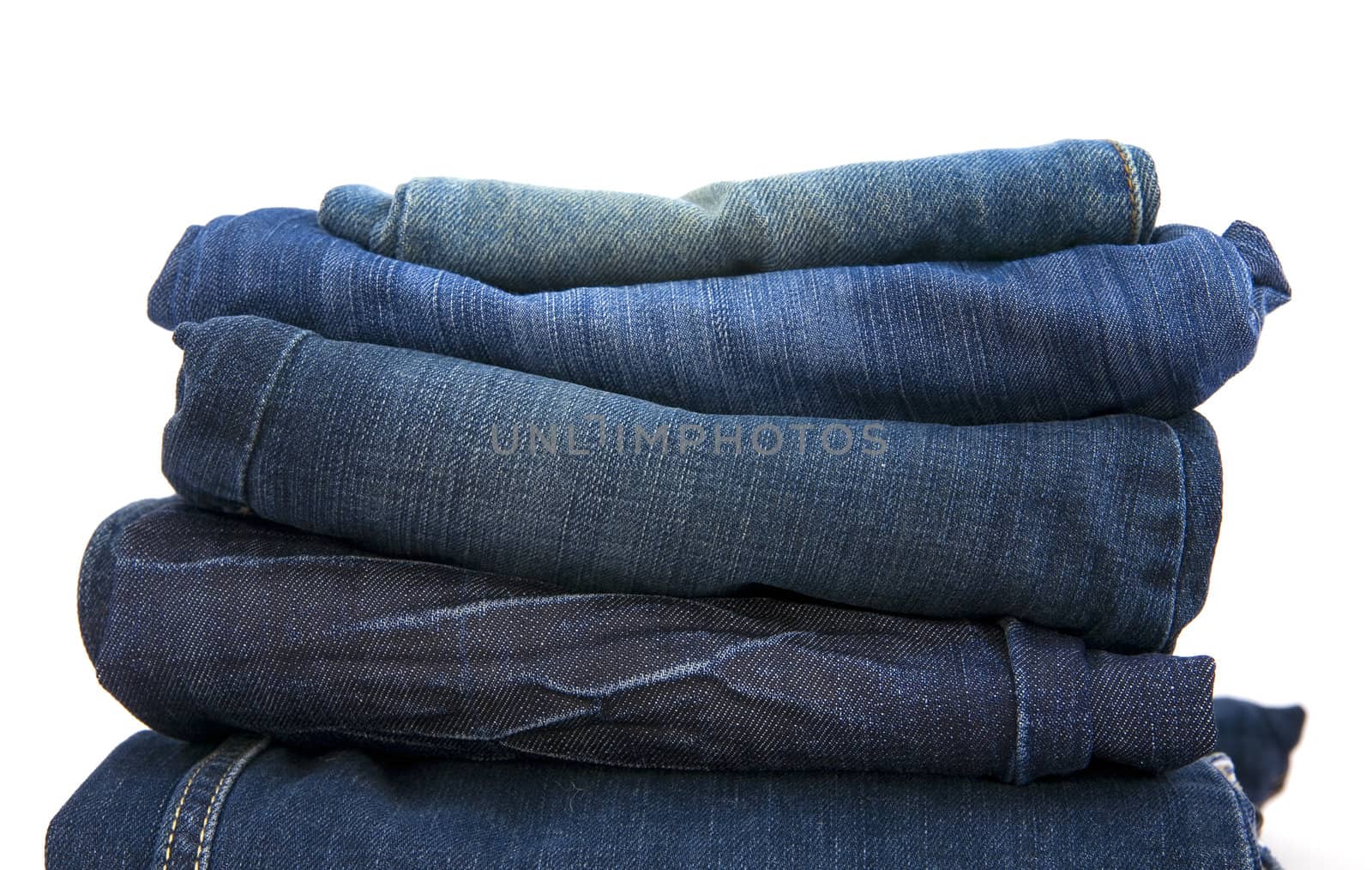 folded new blue jeans on a white background