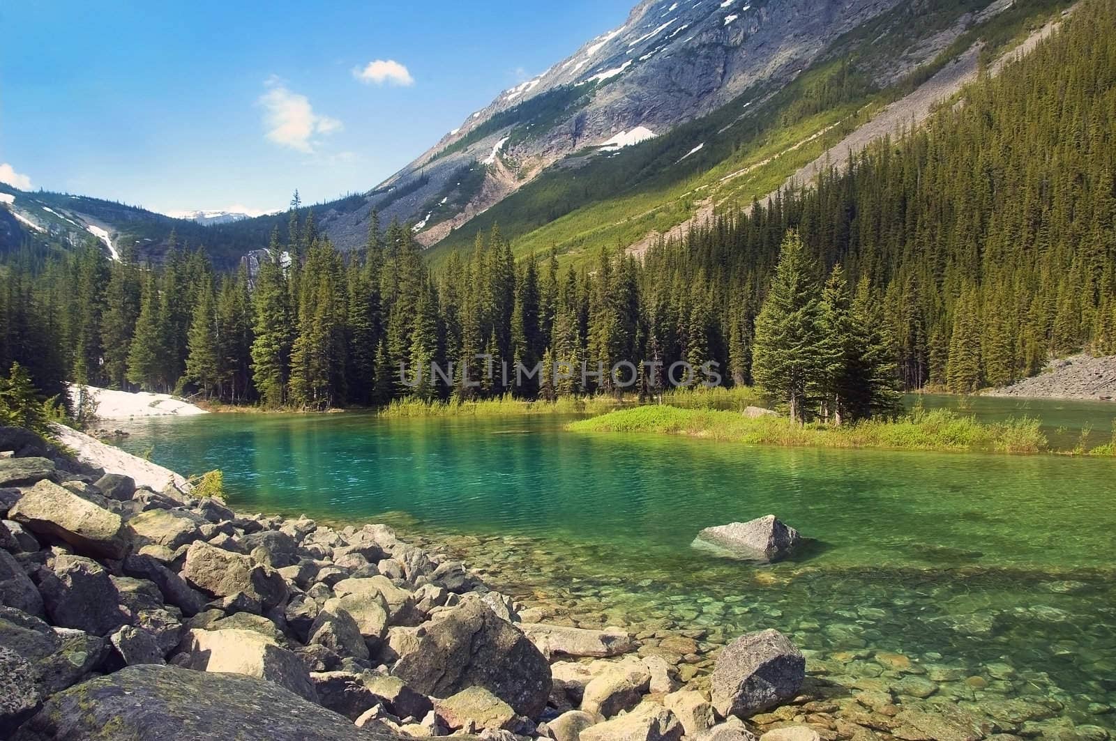 emerald lake at the foot of  the mountains in Sabwatcha canyon, Canada
