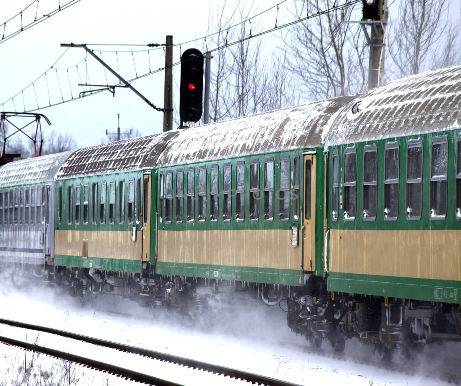 Passenger train passes the snowy line during wintertime in Poland
