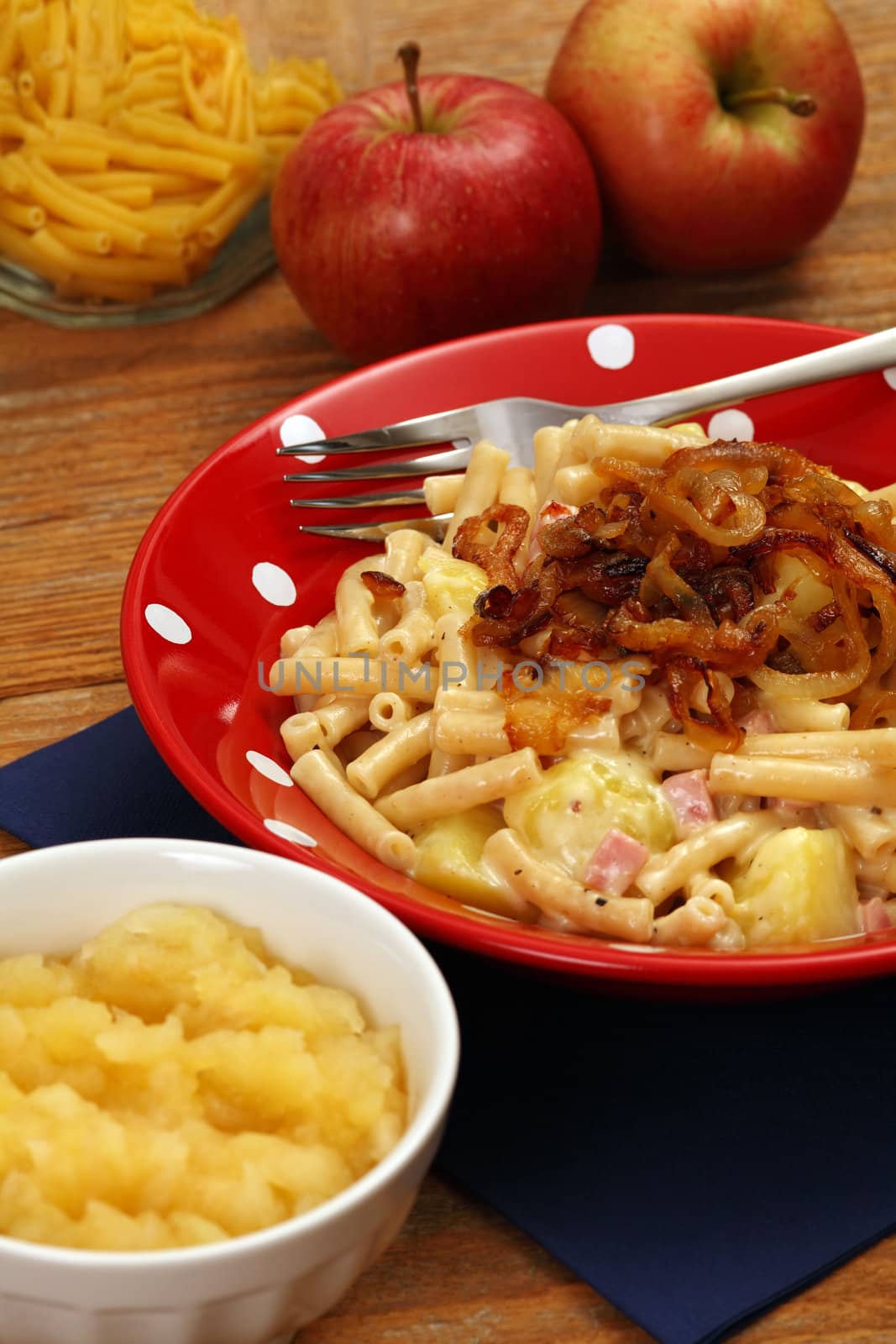 Photo of a bowl of Alplermagronen, or Alpine farmer's macaroni, a traditional Swiss meal made with noodles, potatoes, cheese, onions and served with applesauce.