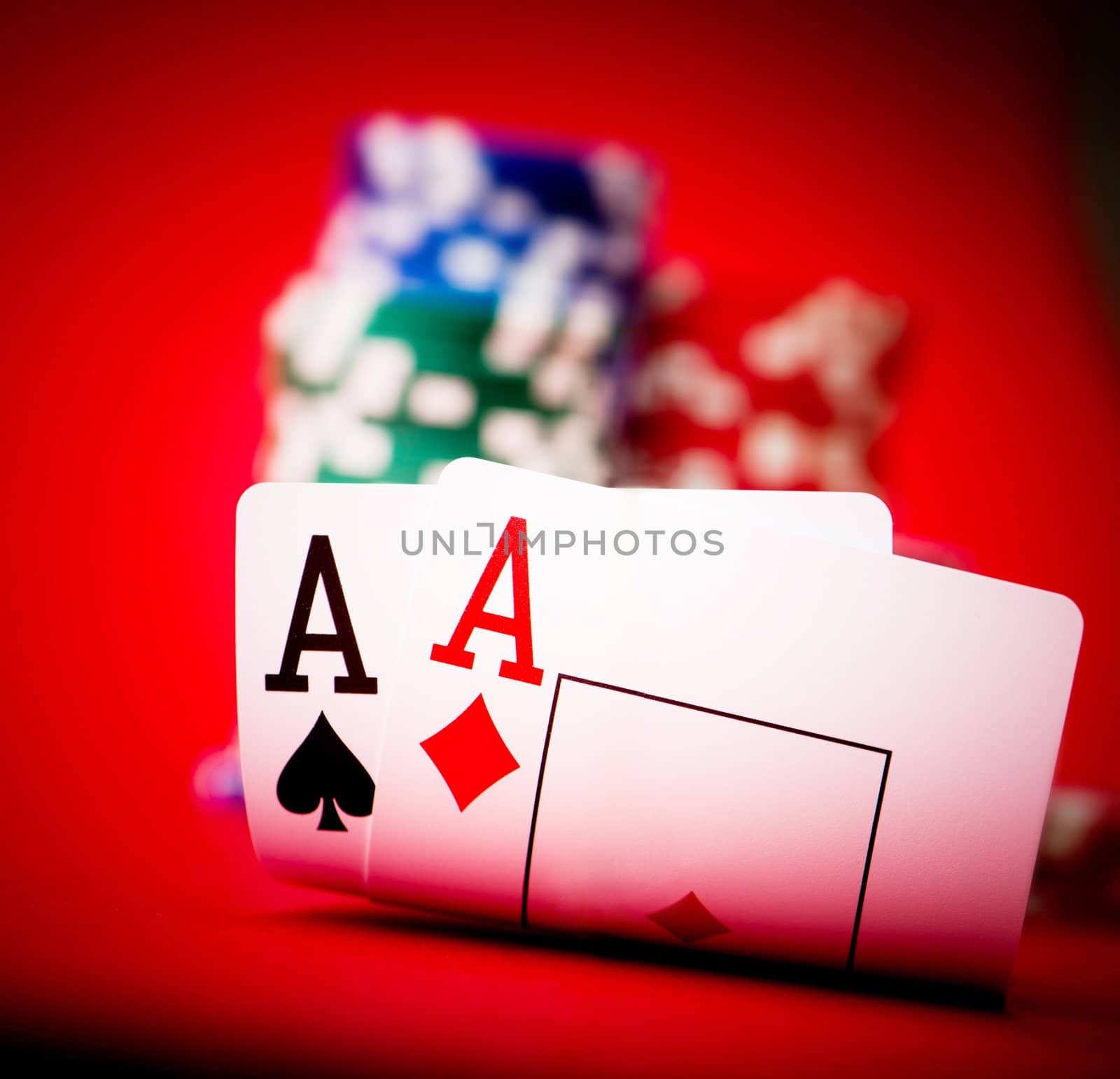 Stack of chips and two aces on a poker table