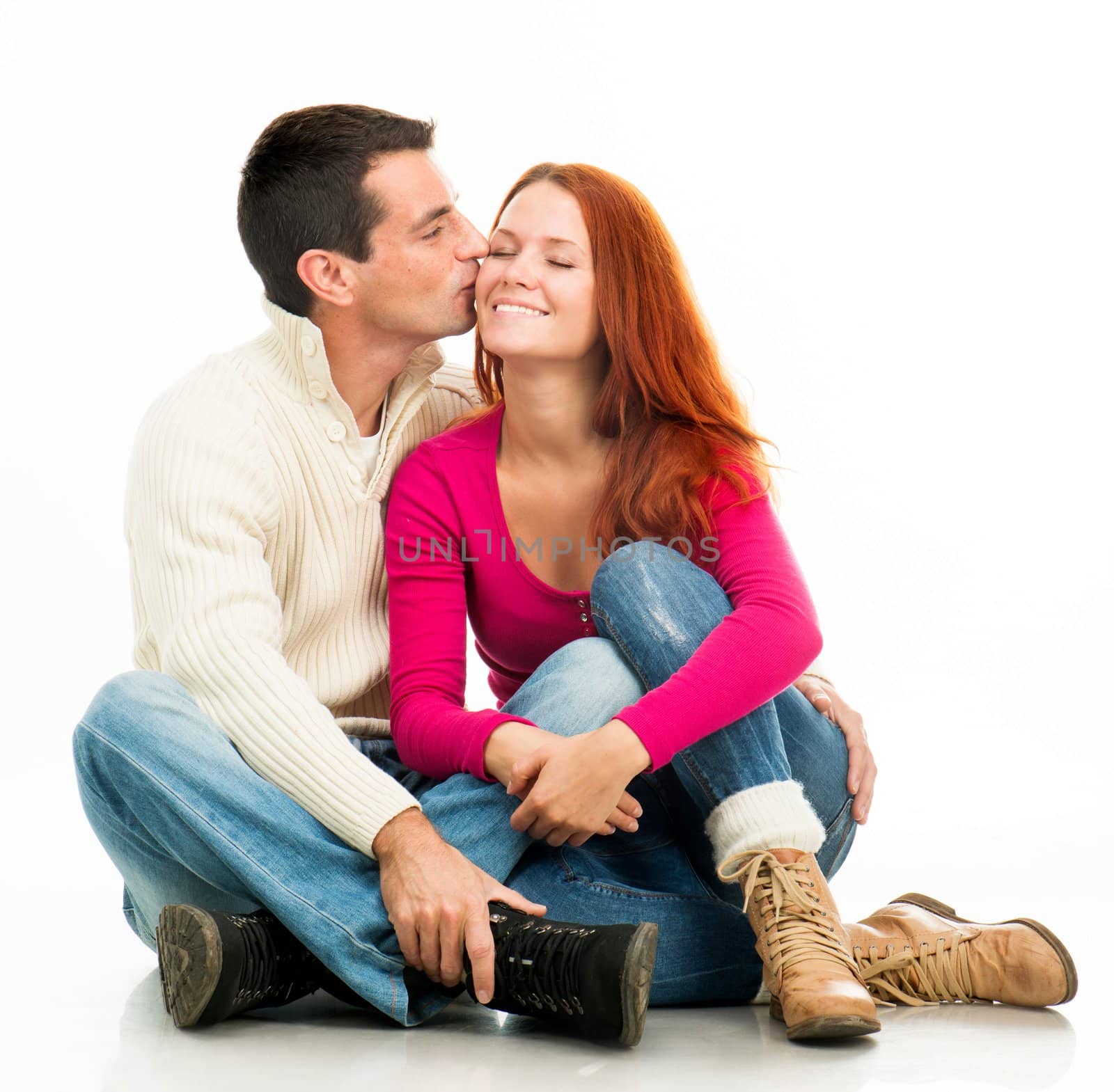 Young happy couple kissing on white background