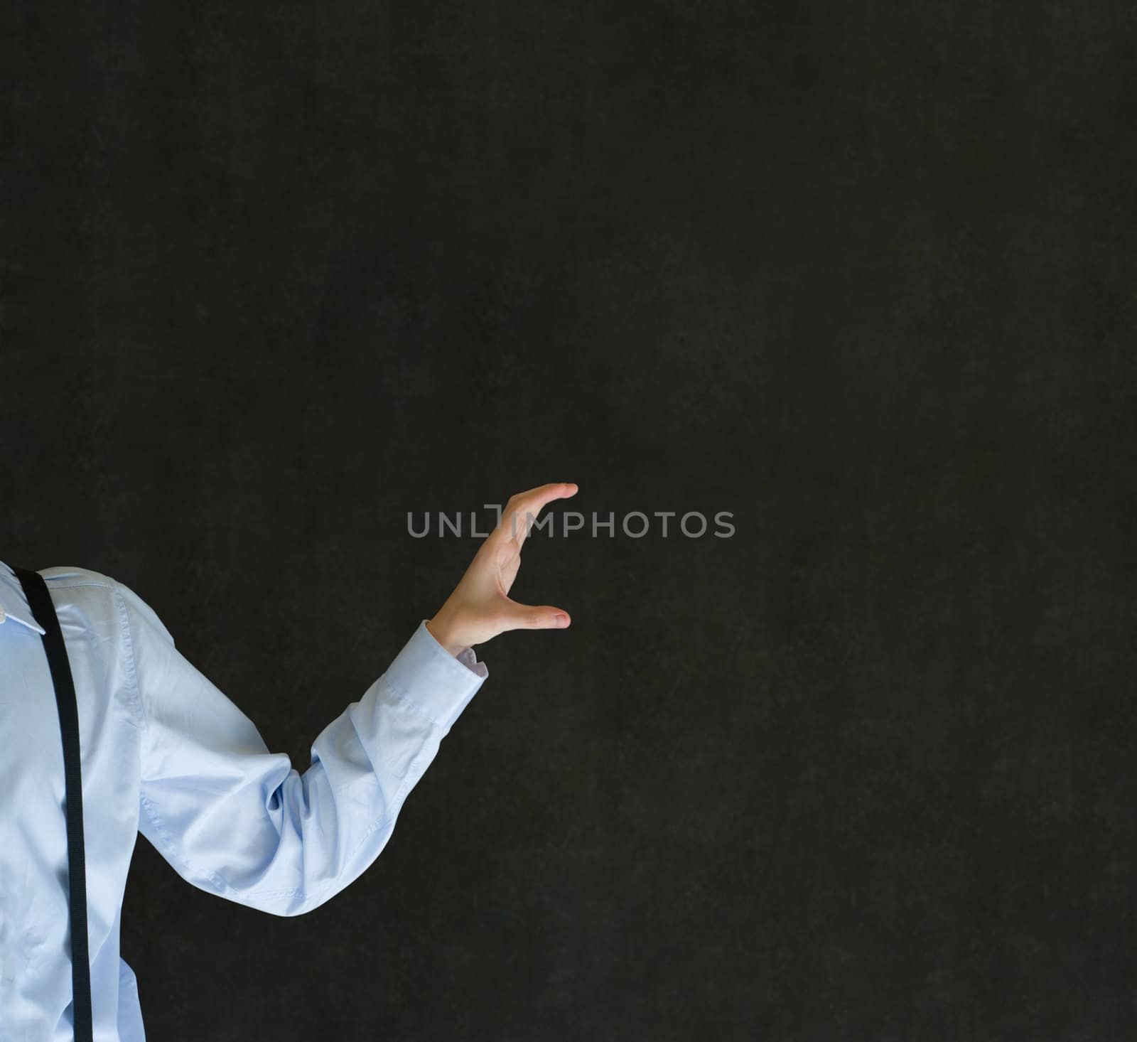 Man holding something or anything on blackboard background by alistaircotton