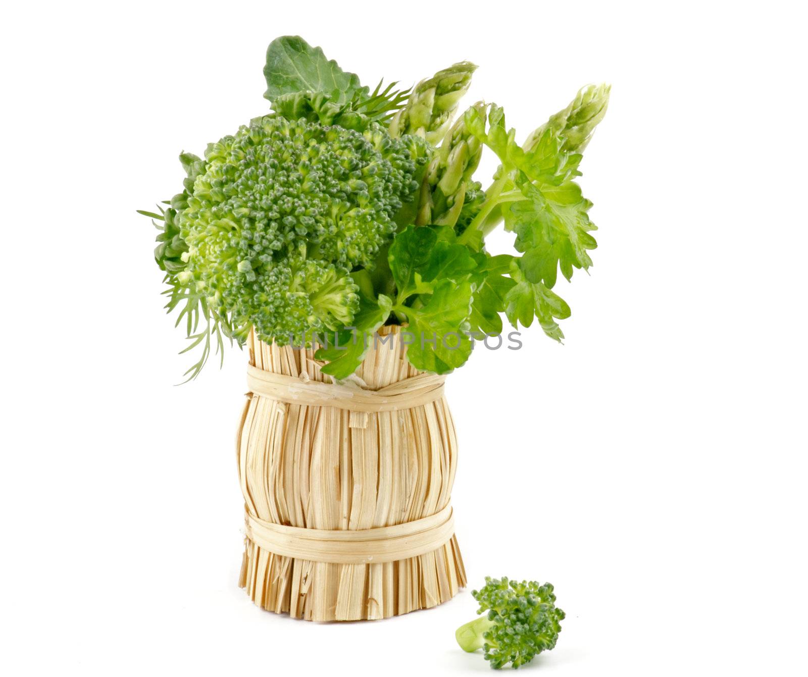 Bouquet of broccoli, asparagus, dill, parsley in wicker basket isolated on white background
