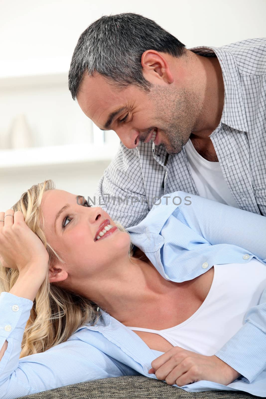 Romantic couple laying on couch by phovoir