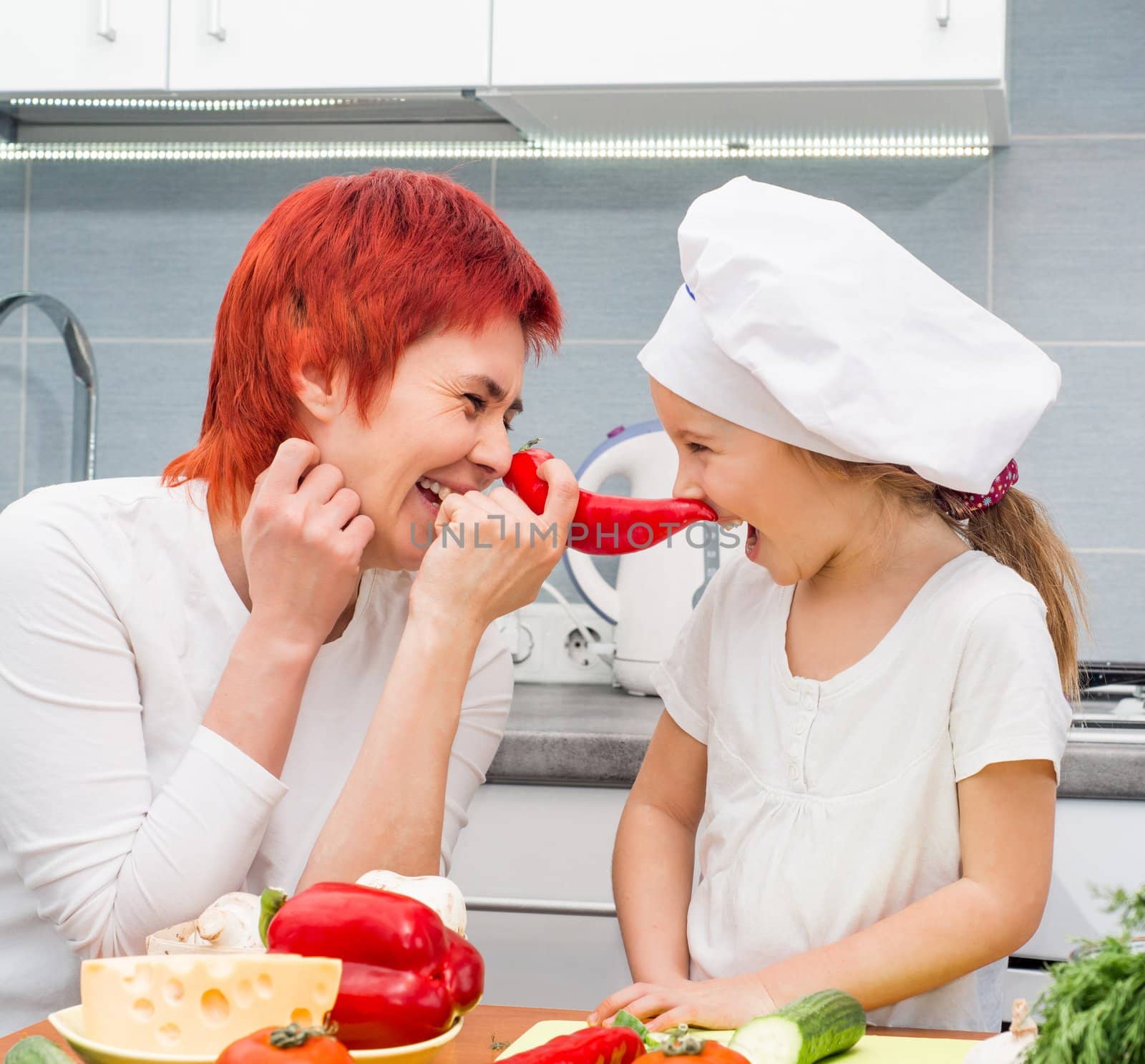 Mother and daughter in the kitchen with pepper