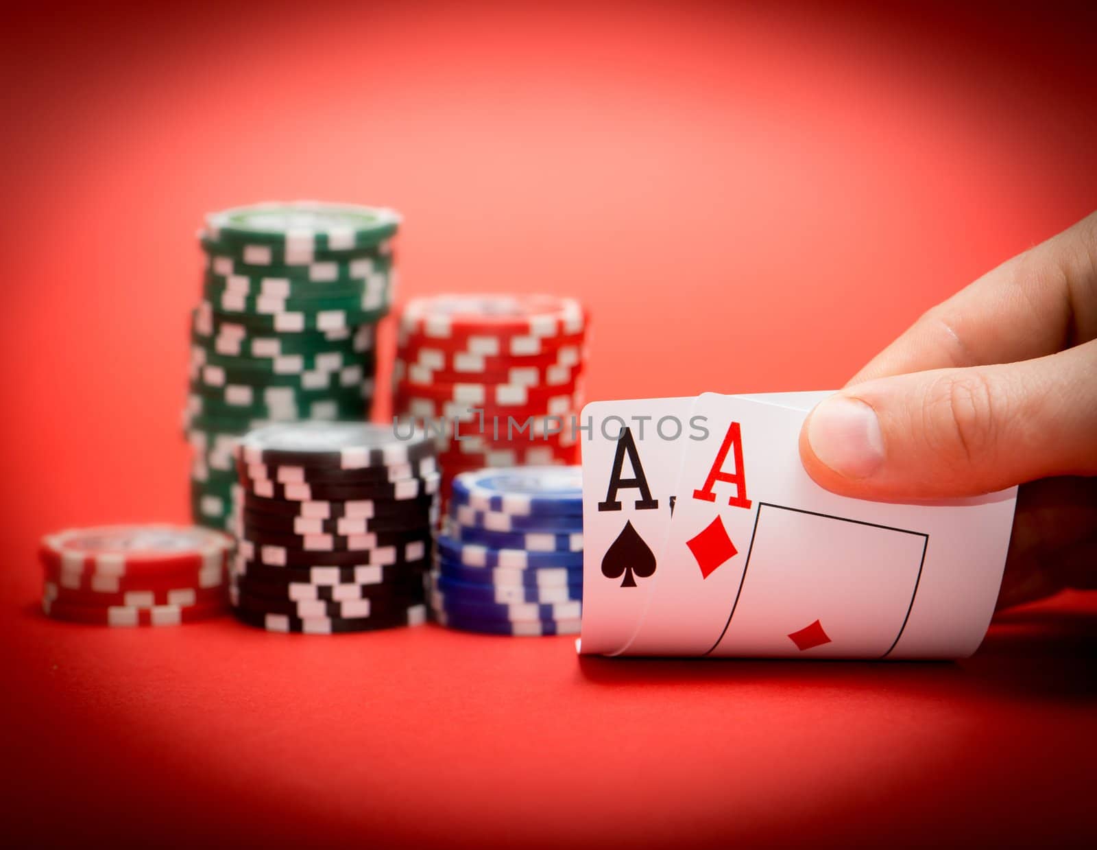 Stack of chips and two aces on a red poker table