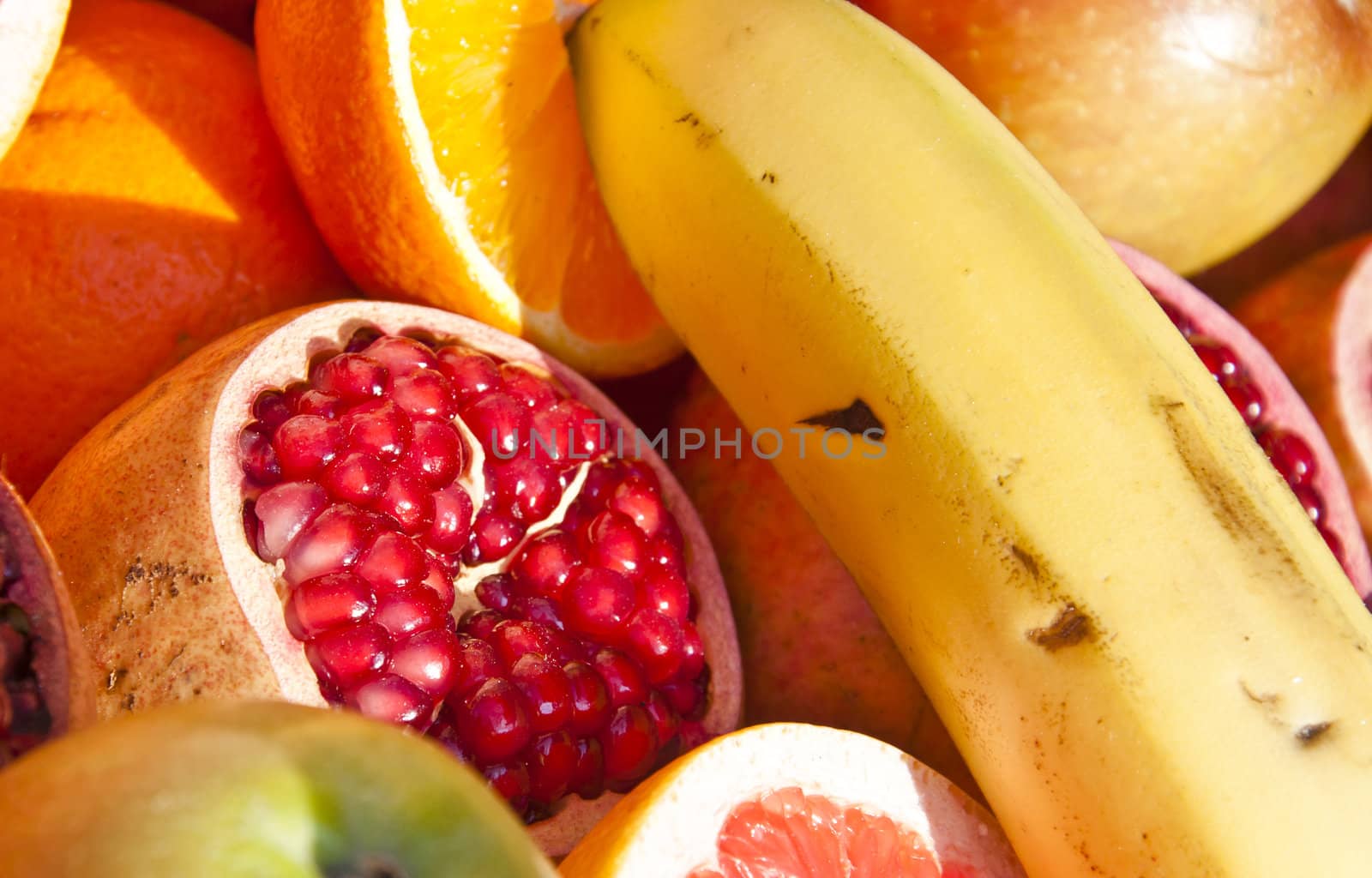 Detail of an open pomegranate with whole ones in the background