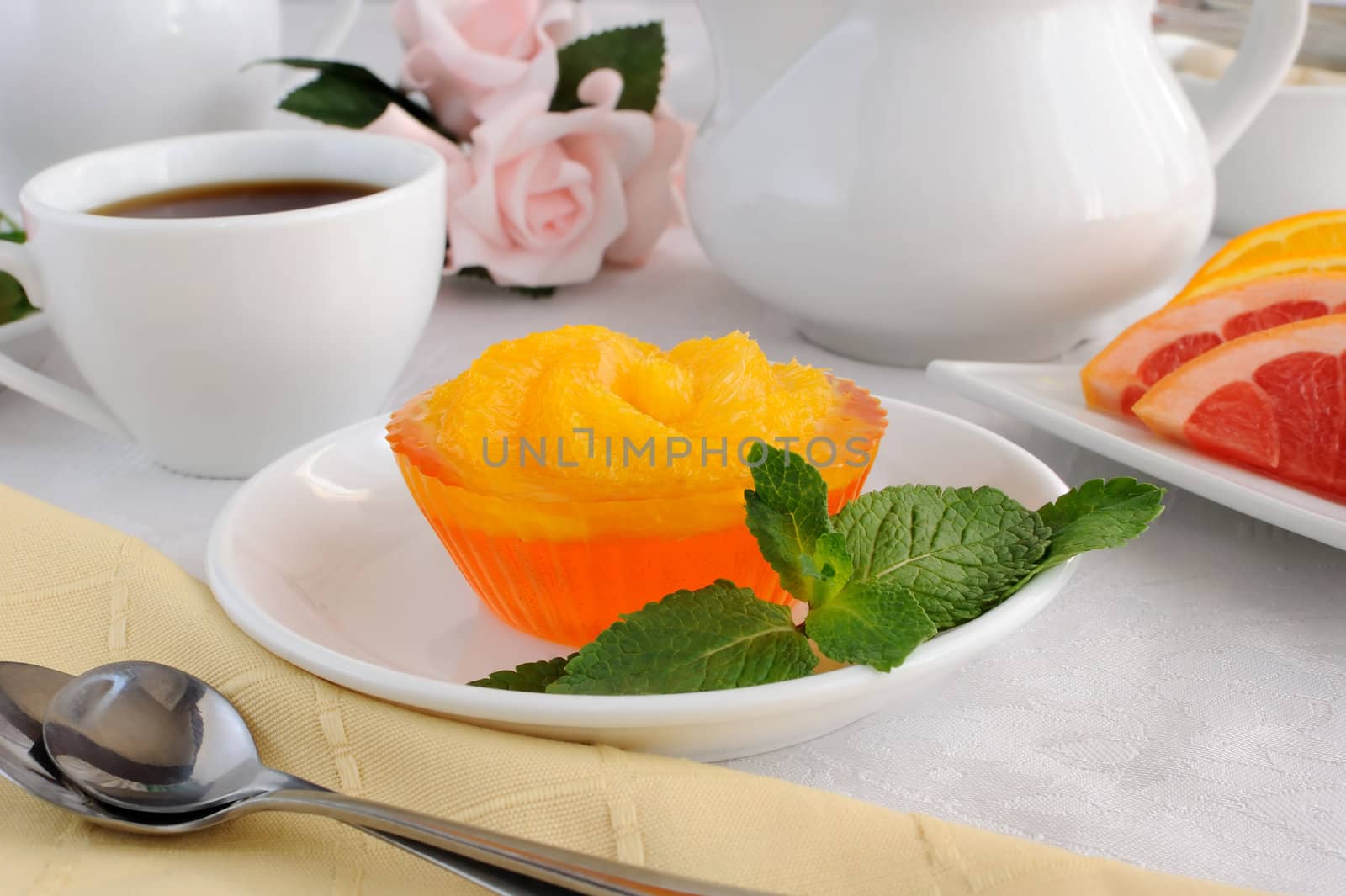 Dessert of orange jelly with fresh orange slices with a cup of coffee